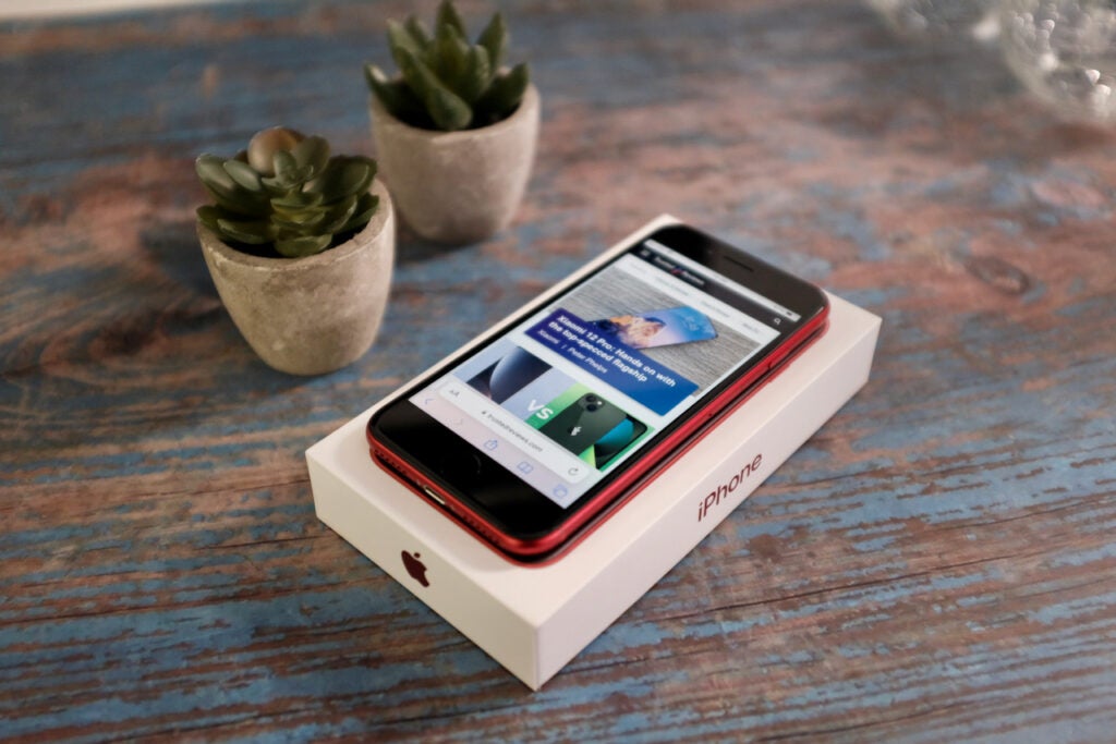 The iPhone SE 2022 in red, along with the box