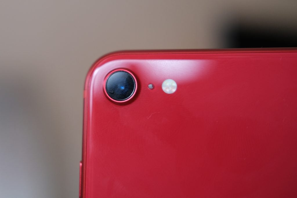 Close up image of a red iPhone SE's back camera section